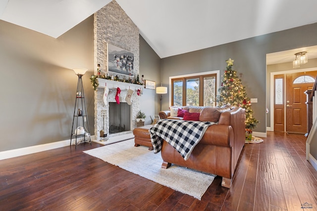 living room with a stone fireplace, dark hardwood / wood-style flooring, and high vaulted ceiling