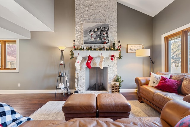 living room featuring a fireplace, high vaulted ceiling, and hardwood / wood-style flooring