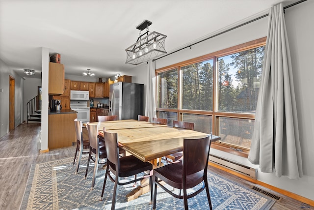 dining area with wood-type flooring and a baseboard radiator