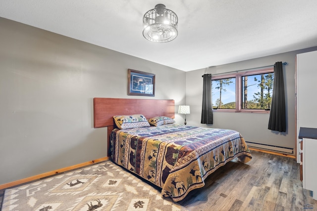 bedroom featuring hardwood / wood-style flooring and a baseboard radiator