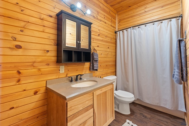 bathroom with hardwood / wood-style flooring, vanity, wood walls, and toilet