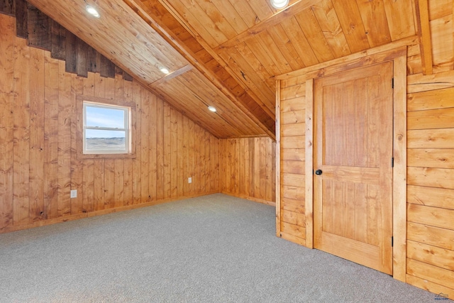 additional living space featuring carpet, lofted ceiling with beams, wood ceiling, and wood walls