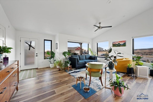 living room with ceiling fan, lofted ceiling, and light hardwood / wood-style flooring