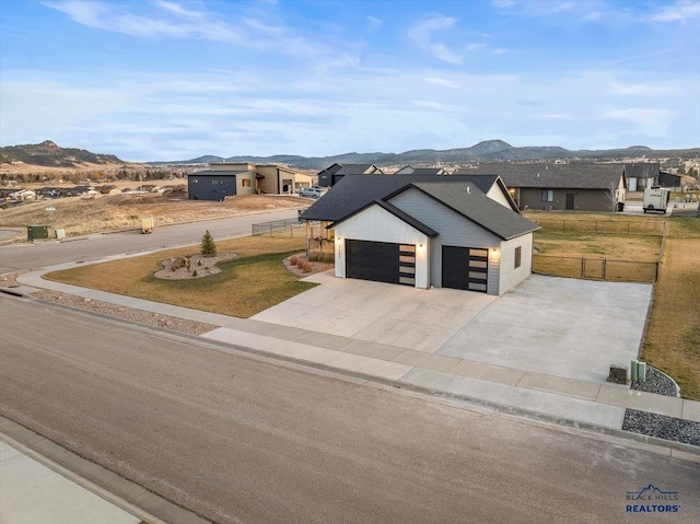 view of front facade with a mountain view, a garage, and a front yard