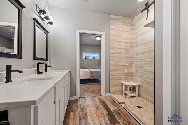 bathroom with hardwood / wood-style floors, vanity, and walk in shower