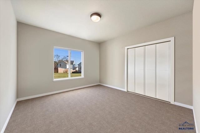 unfurnished bedroom with a closet and carpet