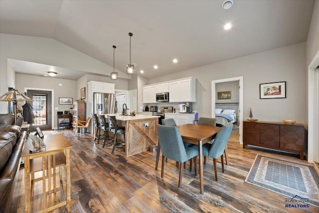 dining area with dark hardwood / wood-style flooring and vaulted ceiling