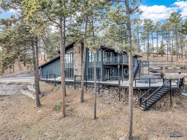 rear view of house featuring a wooden deck