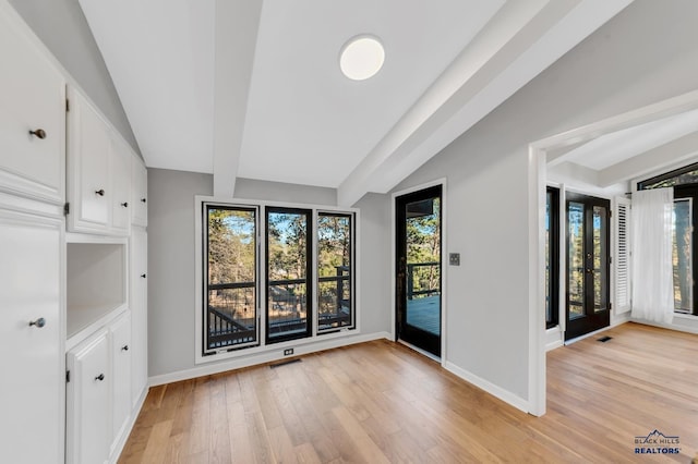 interior space with vaulted ceiling with beams and light wood-type flooring