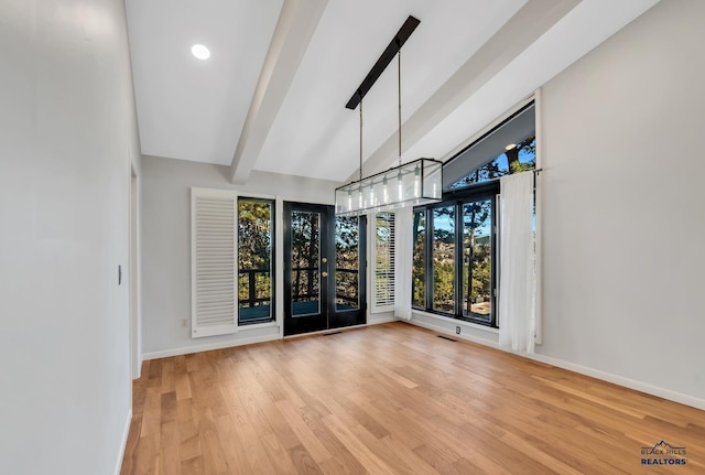 spare room with hardwood / wood-style floors and lofted ceiling with beams