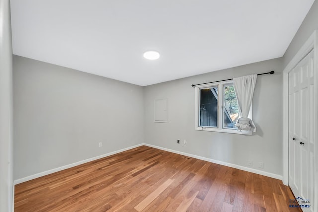 unfurnished bedroom featuring hardwood / wood-style flooring and a closet