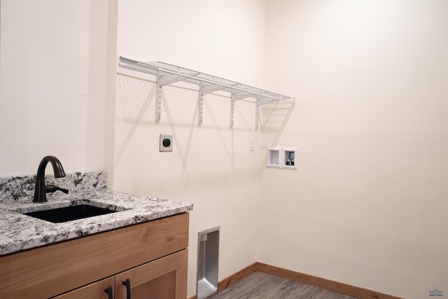 laundry area featuring hookup for an electric dryer, light hardwood / wood-style floors, sink, and washer hookup