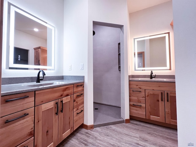 bathroom featuring hardwood / wood-style floors, vanity, and a shower