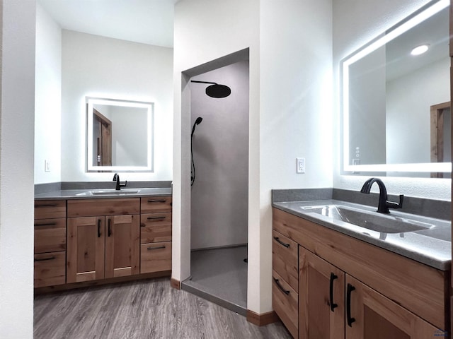 bathroom featuring hardwood / wood-style floors, vanity, and walk in shower