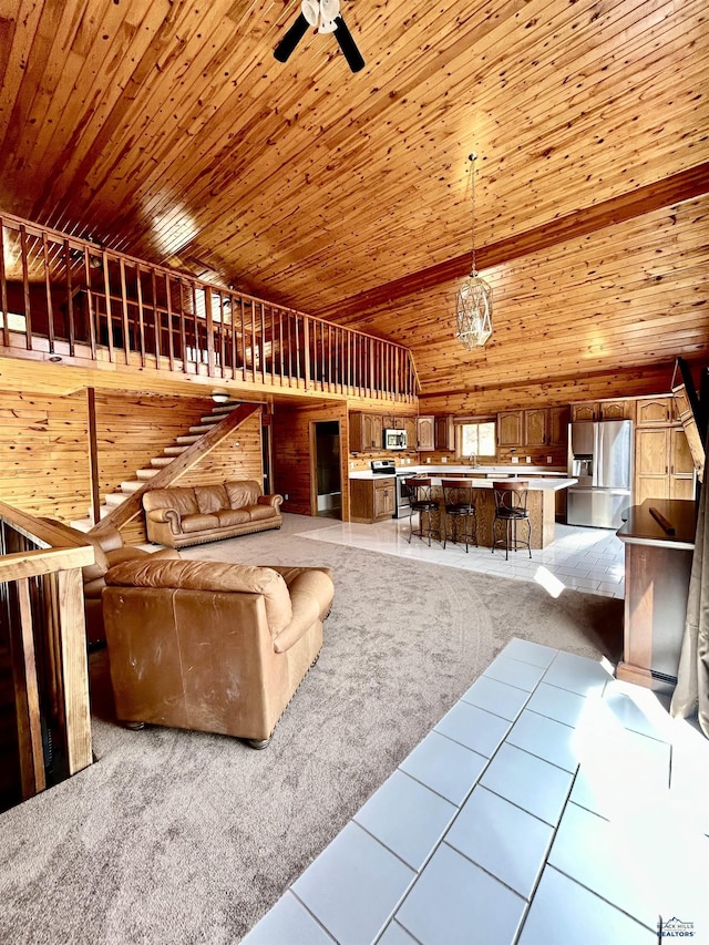 unfurnished living room with light carpet, high vaulted ceiling, ceiling fan, and wooden ceiling