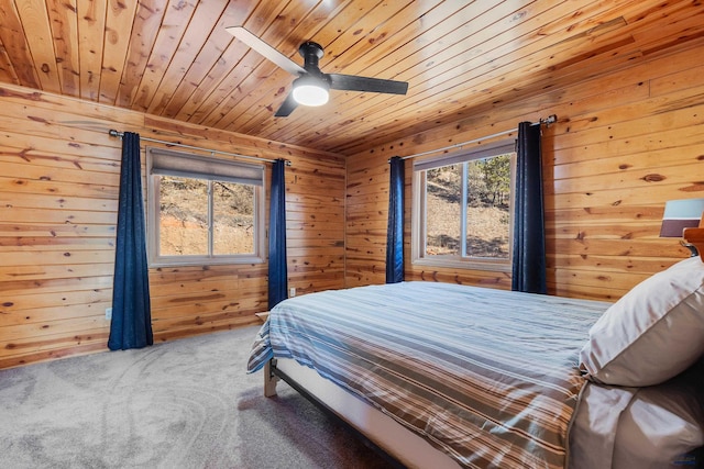 bedroom with carpet, ceiling fan, wood walls, and wood ceiling