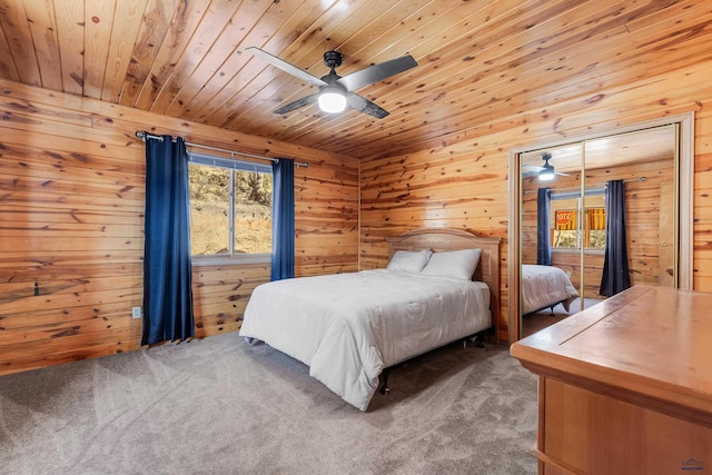 bedroom with ceiling fan, wooden walls, carpet floors, and wooden ceiling