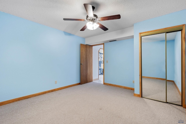 unfurnished bedroom with light carpet, a textured ceiling, and ceiling fan