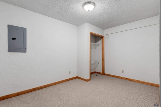 unfurnished bedroom featuring carpet floors, a textured ceiling, electric panel, and a closet