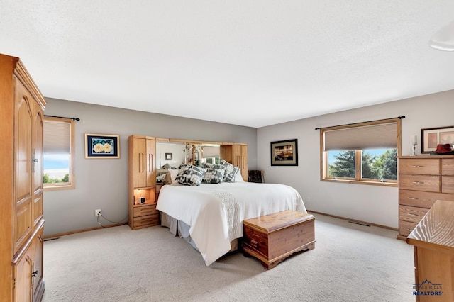 bedroom featuring light colored carpet and multiple windows