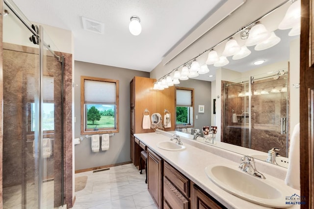 bathroom featuring a textured ceiling, vanity, and an enclosed shower