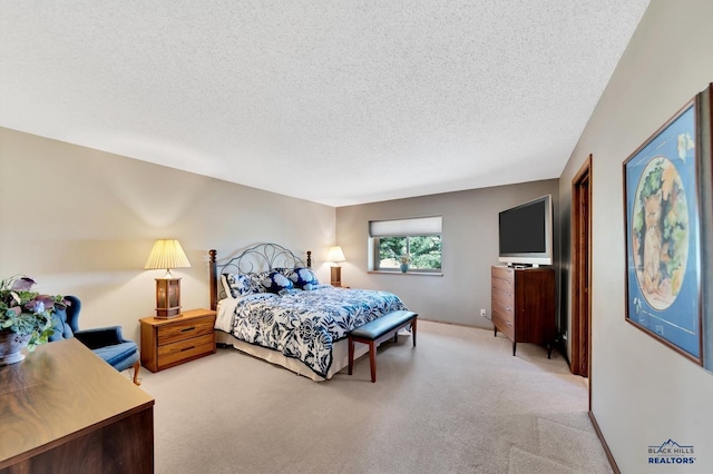 bedroom featuring light colored carpet and a textured ceiling