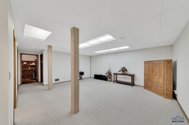 basement with carpet and a paneled ceiling