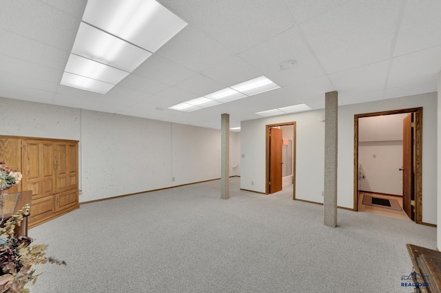 basement with light carpet and a drop ceiling