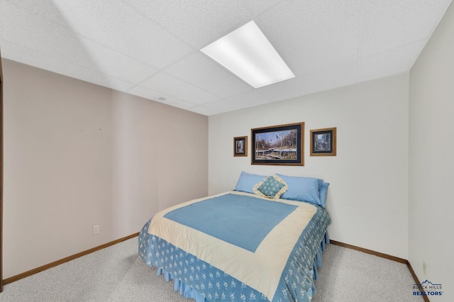 carpeted bedroom featuring a drop ceiling