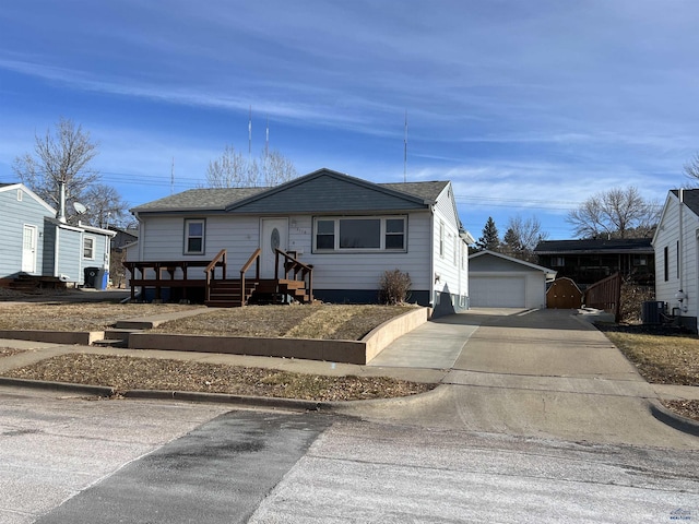 view of front of home featuring central AC unit, a garage, and an outdoor structure