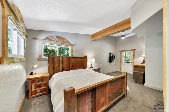 bedroom featuring beam ceiling, carpet floors, and a textured ceiling