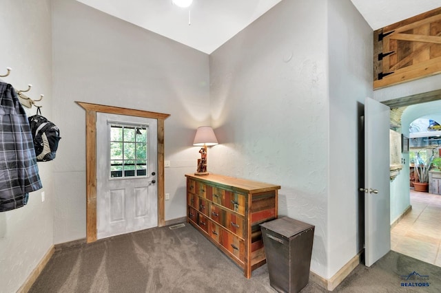 foyer entrance featuring carpet flooring