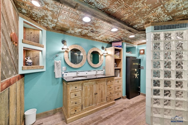 bathroom featuring hardwood / wood-style floors, vanity, and ornamental molding