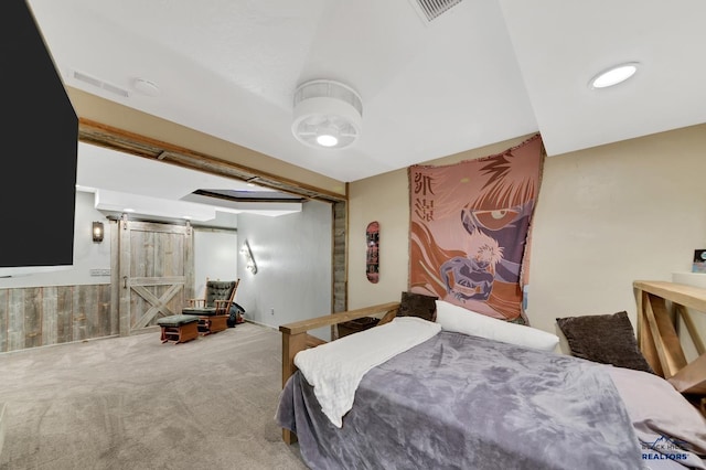 carpeted bedroom with a barn door