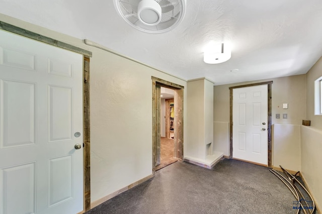 entrance foyer featuring dark colored carpet