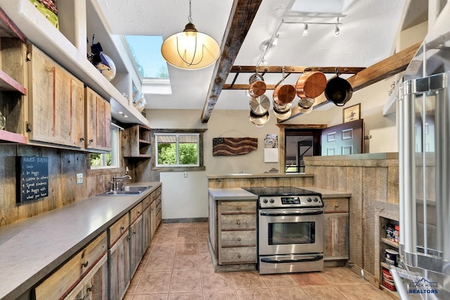 kitchen with sink, a skylight, appliances with stainless steel finishes, beamed ceiling, and decorative light fixtures