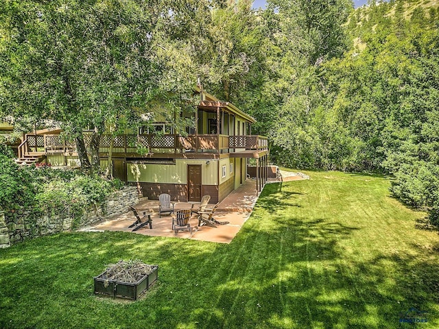 view of yard featuring a fire pit, a patio, and a wooden deck