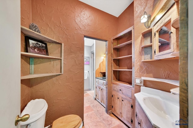 bathroom featuring tile patterned flooring, toilet, and sink