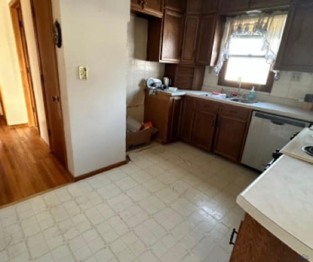 kitchen featuring stainless steel dishwasher, sink, and tasteful backsplash