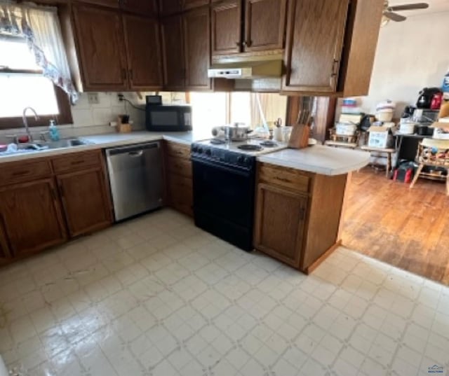 kitchen featuring dishwasher, stove, sink, ceiling fan, and kitchen peninsula