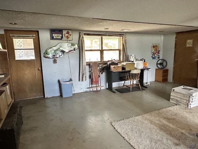 miscellaneous room with concrete flooring and a textured ceiling