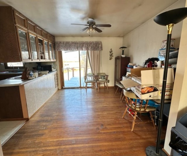 interior space with ceiling fan, dark hardwood / wood-style flooring, and dark brown cabinetry