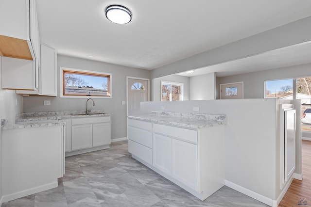 kitchen featuring white cabinetry and sink