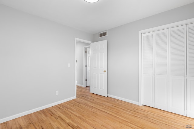 unfurnished bedroom featuring light hardwood / wood-style floors and a closet