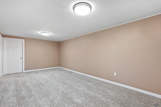 carpeted spare room featuring wooden walls