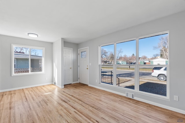 spare room with light hardwood / wood-style flooring and plenty of natural light