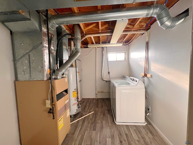 interior space with water heater, washer and dryer, and wood-type flooring