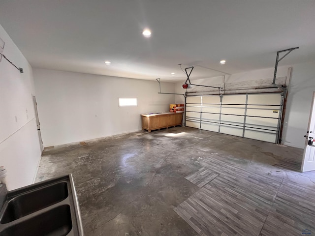 garage with recessed lighting, a sink, and a garage door opener