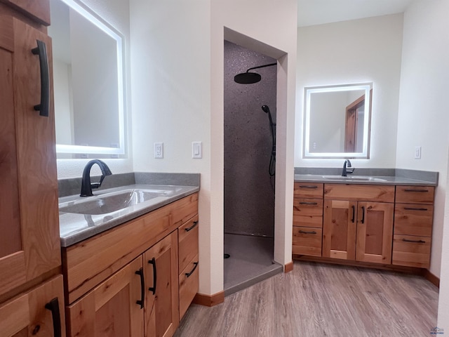 bathroom featuring vanity, wood-type flooring, and walk in shower