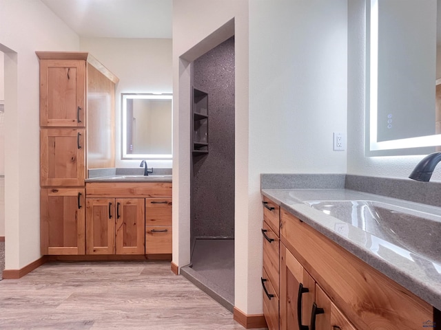 bathroom with vanity, a shower, and wood-type flooring